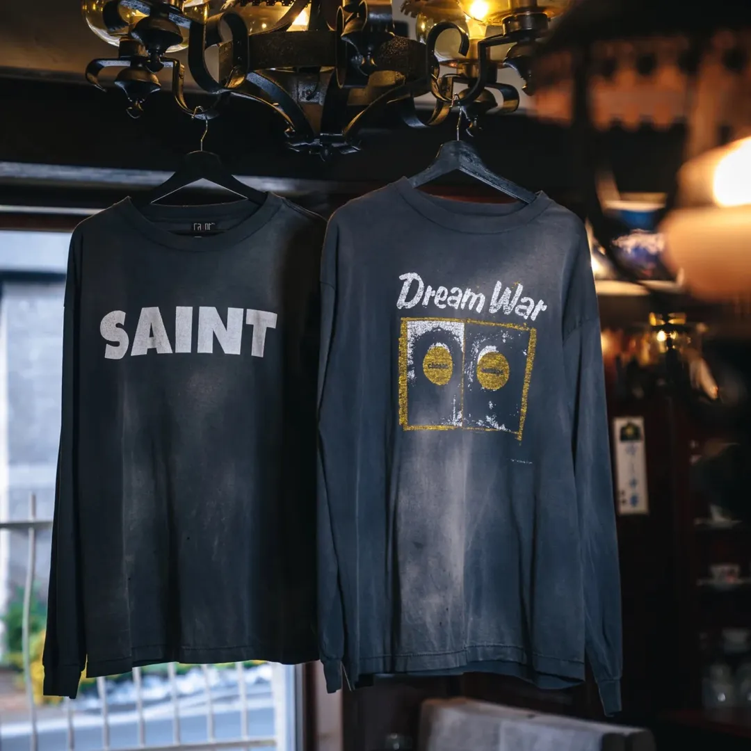 SAINT Mxxxxxx S>N>T LS TEE/BLACK Autumn and winter new style S>N>T slogan crack printed long TEE, washed black S-XL Asut ready-made garments dyed, the whole piece sprayed with horse-hair spray, and then sprayed again to fade the color. The collar and cuffs are frayed. Many hangings are worn NEW VINTAGE. Heavy craftsmanship.